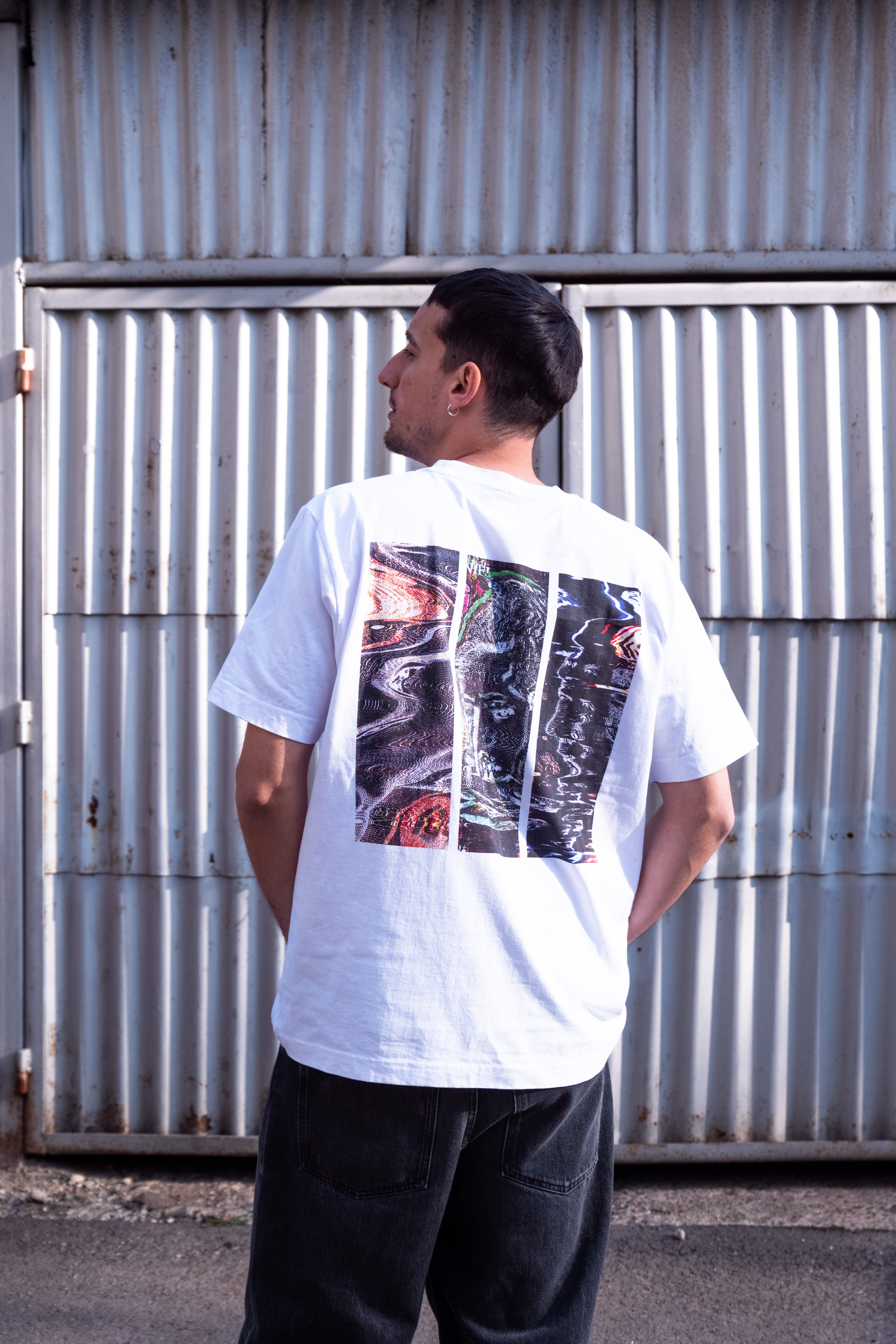 man with a white DTG printed t-shirt posing in front of a garage door